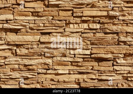 Rock stone brick tile wall has a detailed background texture sepia cream brown color stacked in layers, you can use this image a Stock Photo