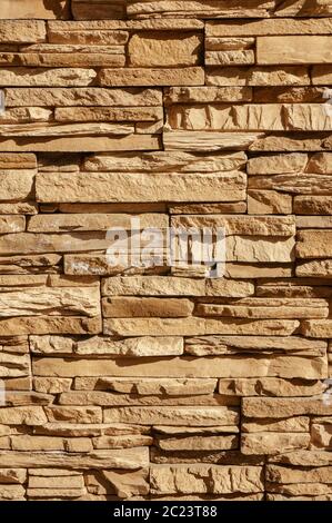 Rock stone brick tile wall has a detailed background texture sepia cream brown color stacked in layers, you can use this image a Stock Photo