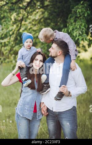Joyful family, having fun outdoors, looking at camera and posing in summer park. Stock Photo