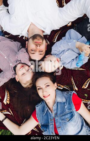 Above view of happy family lying in park together with kids and smiling. Stock Photo