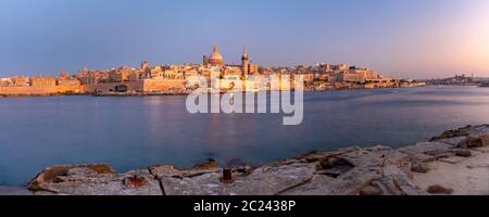 Valletta Skyline with churches of Our Lady of Mount Carmel and St. Paul's Anglican Pro-Cathedral at sunset as seen from Sliema, Valletta, Capital city Stock Photo