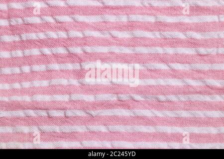 Textile background texture. Top view of details of a empty pink white striped summer dress. Beautiful backdrop for product display montage. Stock Photo