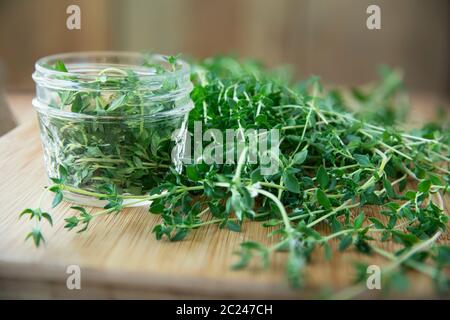 Fresh thyme and glass canning jar for pickled thyme. Stock Photo