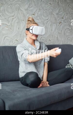 Young woman watching videos or playing with VR glasses on head Stock Photo