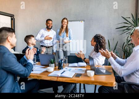 Coworkers Applauding Cheering Colleagues After Successful Speech In Office Stock Photo