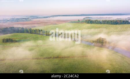 Summer nature landscape aerial panorama. Morning fog over river, meadow and forest. Nature sunlight scene at foggy sunrise. Belarus, Europe Stock Photo