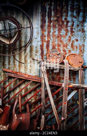 Image of worn rushy tools leaning up against corrugated metal wall. Stock Photo