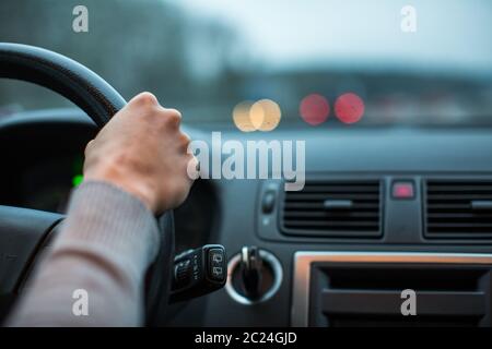 Driver's hands driving a car on a highway (color toned image; shallow DOF) Stock Photo