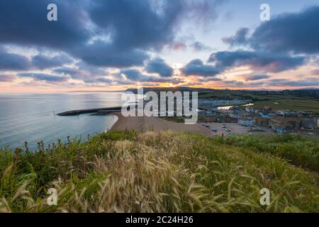 West Bay, Dorset, UK.  16th June 2020.  UK Weather. Dark puffy clouds in the sky shortly before sunset at West Bay in Dorset at the end of a warm sunny day.  Picture Credit: Graham Hunt/Alamy Live News Stock Photo