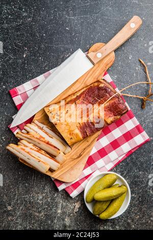 Smoked meat. Tasty bacon on old kitchen table. Top view. Stock Photo