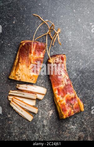 Smoked meat. Tasty bacon on old kitchen table. Top view. Stock Photo