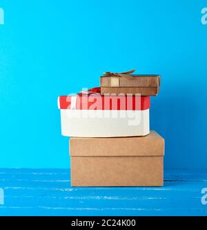 stack of various cardboard boxes on a blue background, festive backdrop Stock Photo
