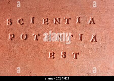 the phrase  “Scientia Potentia Est” written in Latin on a terracotta tablet Stock Photo