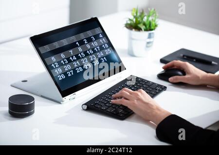 Close-up Of A Business Person Looking At Calendar With Daily Agenda On Laptop Computer Stock Photo