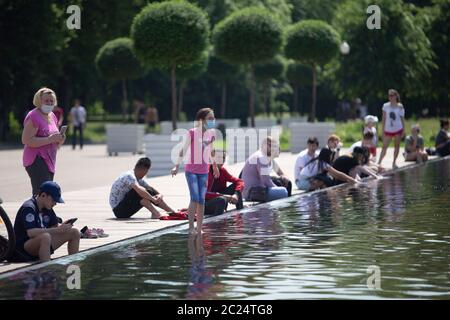 Moscow, Russia. 16th June, 2020. People enjoy their time near a fountain in Gorky Park in Moscow, Russia, on June 16, 2020. Russia added 8,248 COVID-19 cases in the past 24 hours, taking its total to 545,458, the country's coronavirus response center said in a statement Tuesday. The city of Moscow began to spring to life on Tuesday as it entered a new phase. Credit: Alexander Zemlianichenko Jr/Xinhua/Alamy Live News Stock Photo