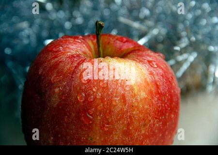 A red apple with yellow dots isolated on blue background Stock Photo