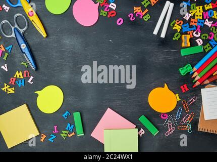 school supplies: multicolored wooden pencils, notebook, paper stickers, paper clips, pencil sharpener and white chalk, copy space Stock Photo