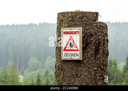 Warning sign for ticks, in the Arnsberg Forest, near Hirschberg, Sauerland, NRW, Germany Stock Photo