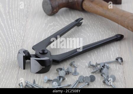 Carpentry tools carpenters pliers pincers claw hammer nails and tacks on bench Stock Photo