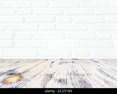 washed wood table with white brick wall texture background. Stock Photo