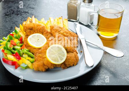 Schnitzel with french fries, homemade, platter, czech beer, vegetable, lemons Stock Photo