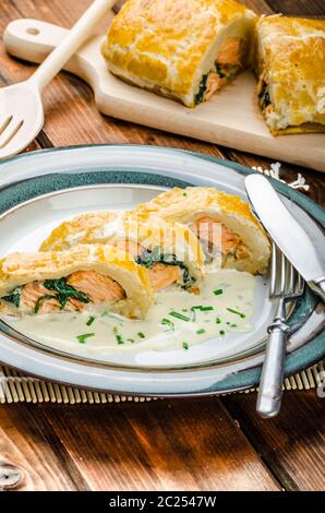 Salmon baked in puff pastry with spinach and garlic Stock Photo