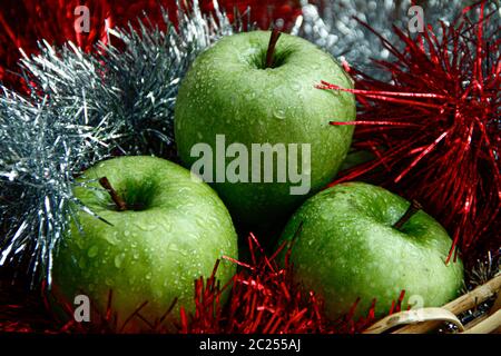 Triple fresh green apples with water drops on them with festive decoration around Stock Photo