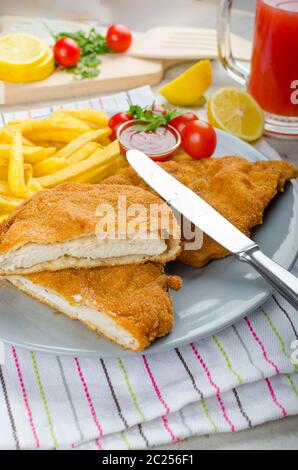 Schnitzel with french fries and a spicy dip, fresh from red orange Stock Photo