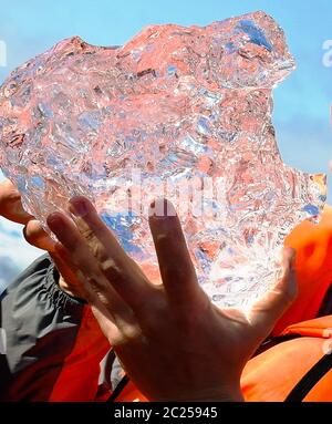 Small icicle from the Jokulsarlon glaciewr lagoon in the hand, Vatnajokull, Iceland Stock Photo