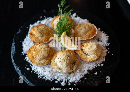 deep fried Hokkaido Scallops Shell with crusty bread serve with lemon and salt. Stock Photo