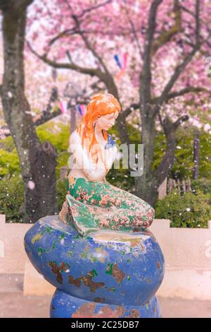 The Little Mermaid from Hans Christian Andersen's book under the cherry blossoms of Asukayama Park in the Kita district, north of Tokyo. Stock Photo