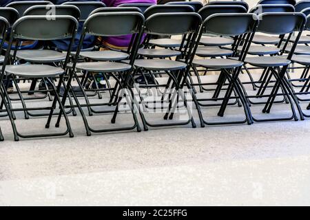 Rows of black folding chairs empty Stock Photo