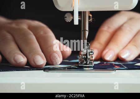 Woman hands using the sewing machine at home during quarantine Stock Photo