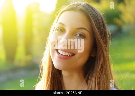 Portrait of smiling young woman with sunlight flare Stock Photo