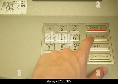 Male hand enters code at cash dispenser. Money payment Stock Photo