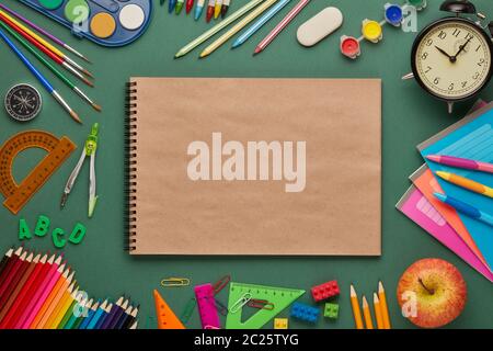 https://l450v.alamy.com/450v/2c25tyg/blank-writing-book-alarm-clock-apple-and-stationery-accessories-on-green-background-top-view-copy-space-school-accessories-for-education-and-dev-2c25tyg.jpg