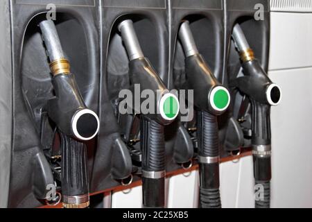 Four fuel nozzles handles at gas station Stock Photo