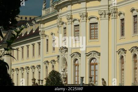 Facade of a baroque palace in yellow and light gray with rows of windows Stock Photo