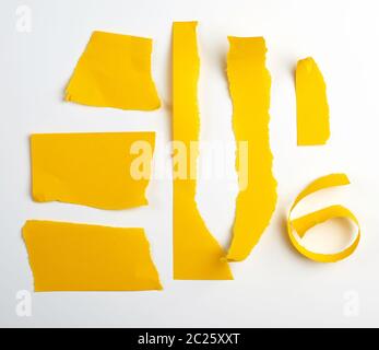 various torn strips of yellow paper on a white background, flat lay Stock Photo