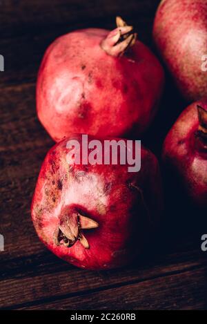 Four ripe pomegranate on rustic wooden table Stock Photo