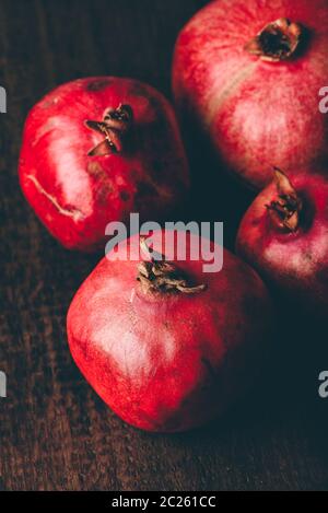 Four ripe pomegranate on rustic wooden table Stock Photo