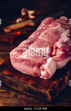 Pork loin joint on cutting board with spices Stock Photo