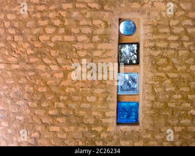 Brick wall with colored glass brick as windows in a rustic house Stock Photo