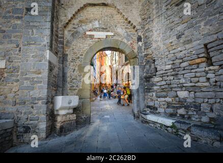 Tourists sight-see and shop inside the ancient town gate of the coastal village of Porto Venere, on the Ligurian coast of Italy. Stock Photo