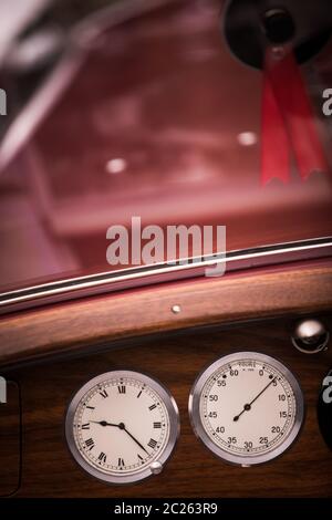 Color close up shot of a tachometer and a clock on a vintage car's dashboard. Stock Photo