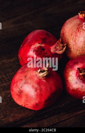 Four ripe pomegranate on rustic wooden table Stock Photo