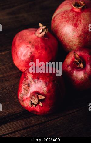 Four ripe pomegranate on rustic wooden table Stock Photo