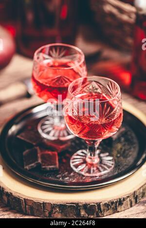 Homemade red currant nalivka and chocolate on metal tray Stock Photo