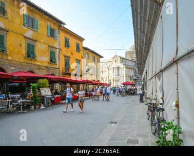 Tourists enjoy a late afternoon on the main street of cafes leading to the Pisa Square of Miracles, in the Tuscan city of Pisa, Italy Stock Photo