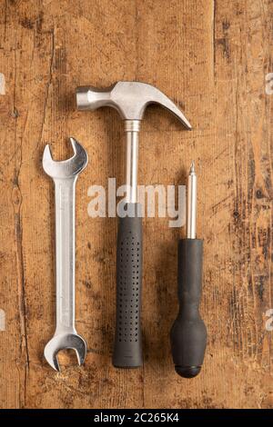 Hammer, cutting plier, screwdriver and a wrench key on a wooden background Stock Photo